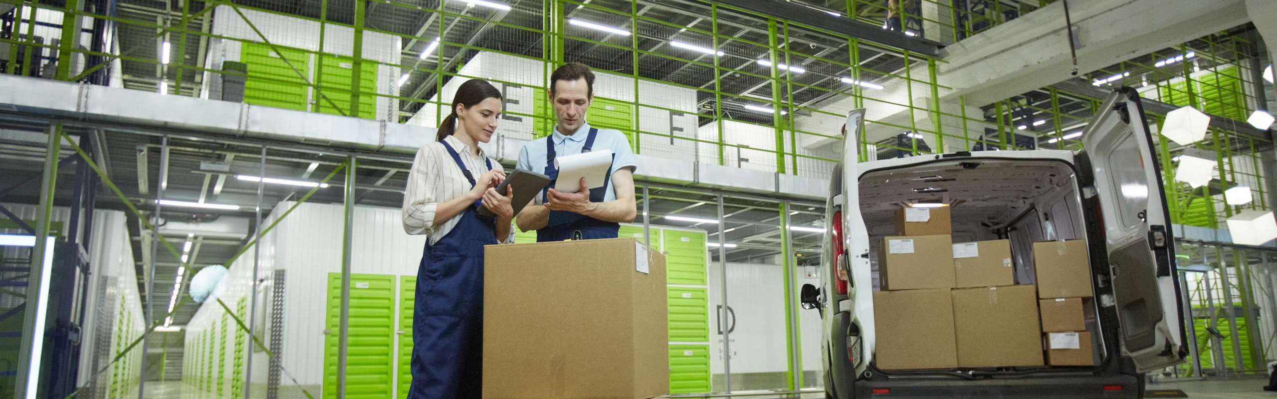 Two people packing parcels in boxes while working in delivery service